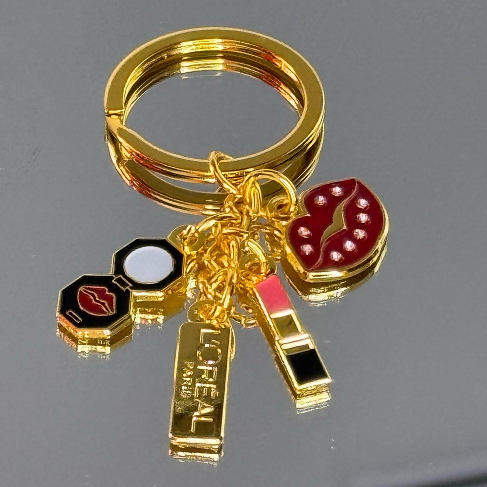 L’Oréal Keychain w/4 charms including a lipstick, lips, compact, & L’Oréal charm